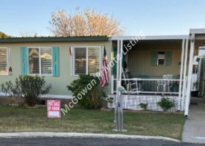 image of front exterior including carport and large shed